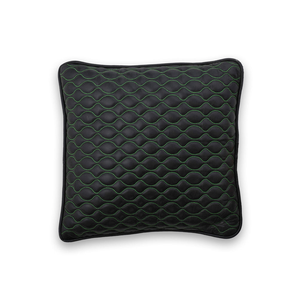 Black quilted pillow with green stitching on a white background

