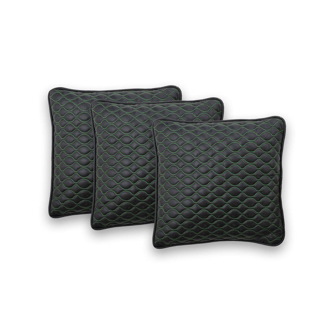 Three quilted dark green cushions on a white background

