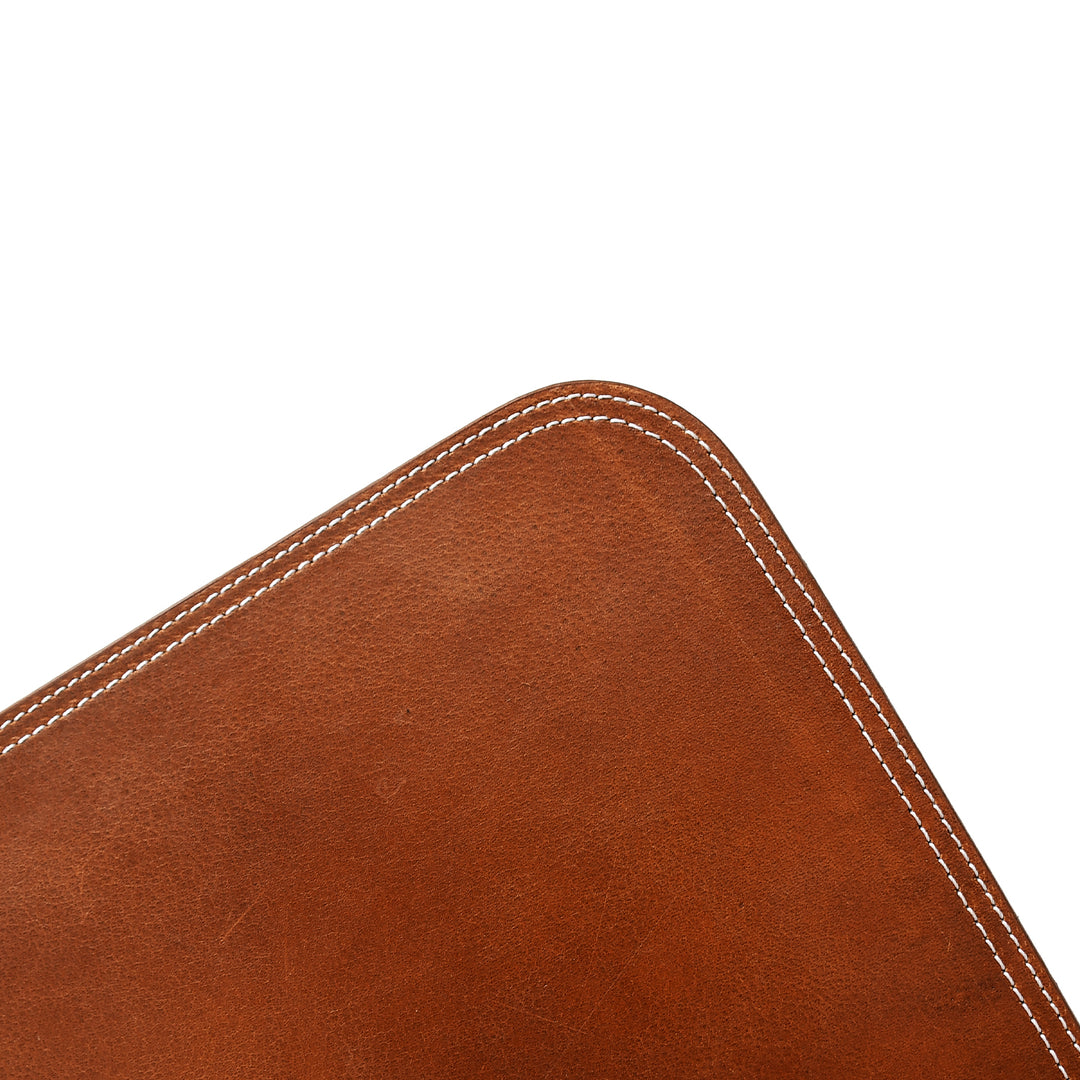 Close-up of a brown leather corner with white contrast stitching on a white background.