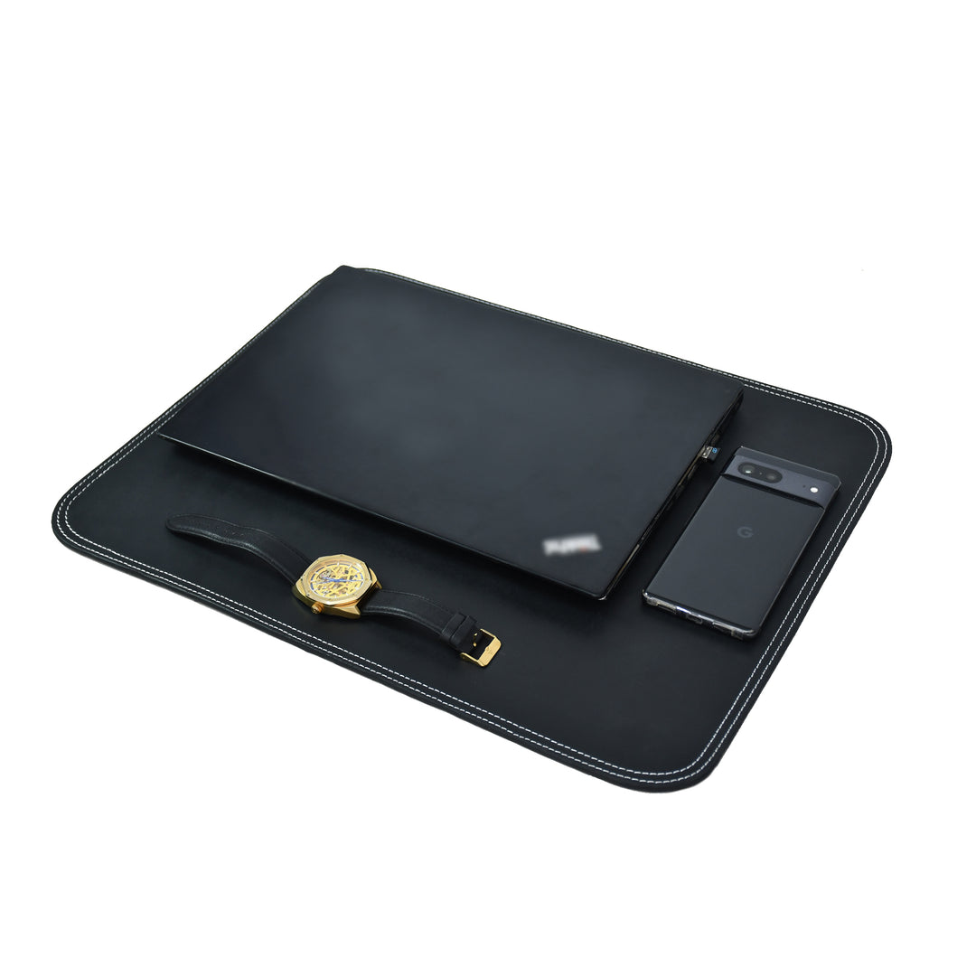 Black leather table mat with white contrast stitching on a white background.