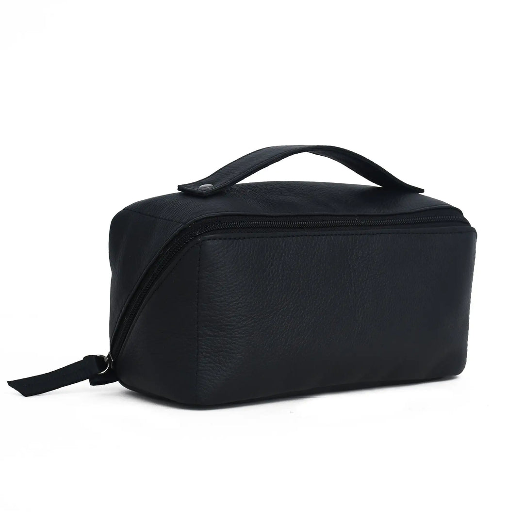 A black pebbled faux-leather cosmetic bag with a top handle and zippered closure, shown from a three-quarters angle on a white background.