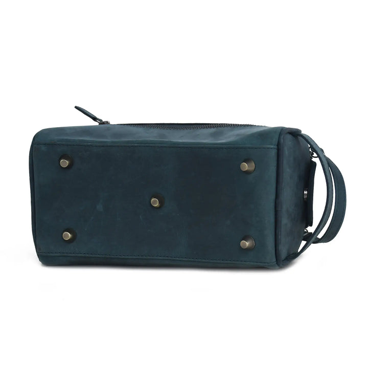 Blue leather toiletry bag with brass rivets on a white background