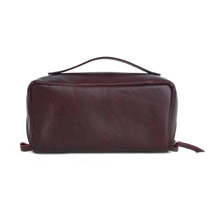 A dark burgundy pebbled leather toiletry bag with a top handle and zipper closure, shown against a plain white background.