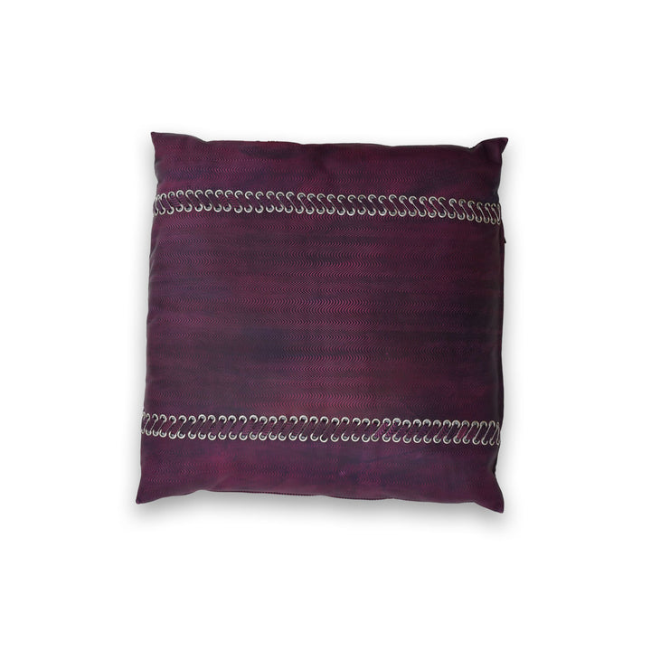 Purple pillow with silver embellishments on a white background

