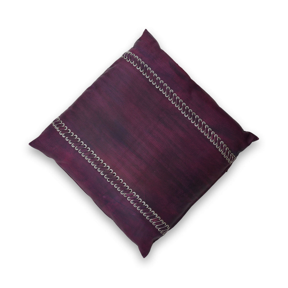 Purple pillow with decorative stitching on a white background

