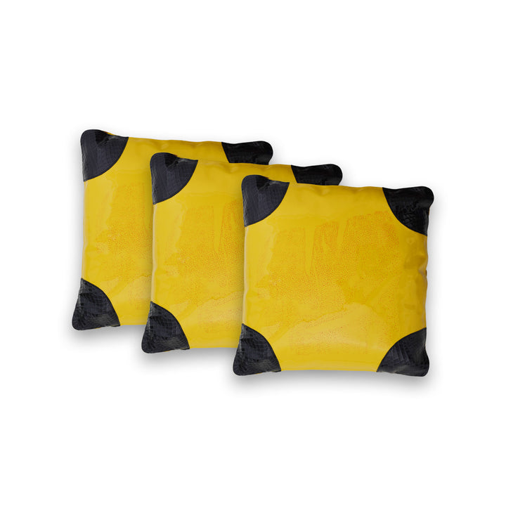 Three yellow pillows with black accents on a white background

