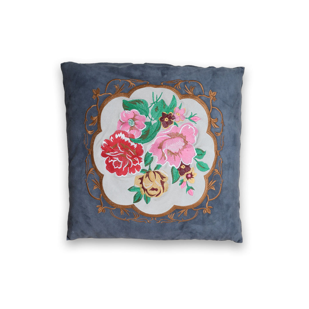 Decorative pillow with floral embroidery on a blue background