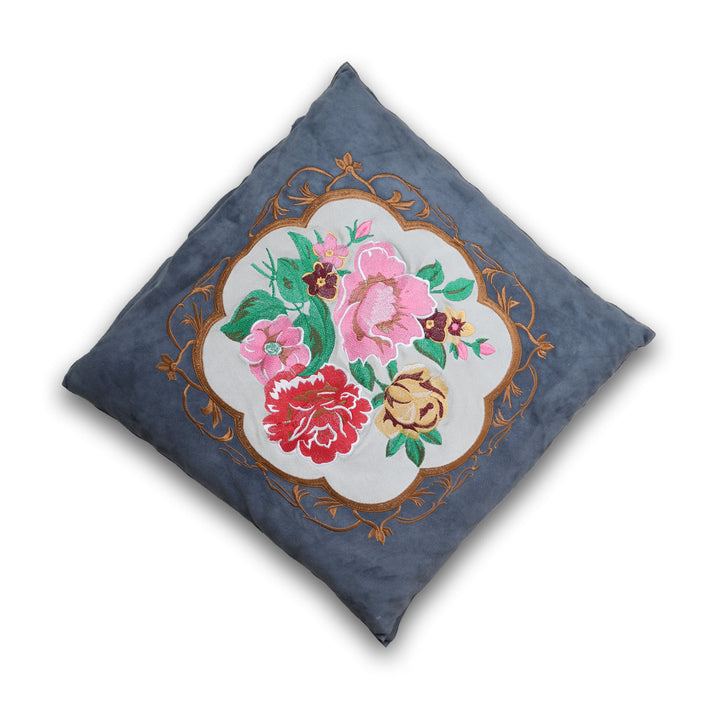 Decorative pillow with floral embroidery on a blue background