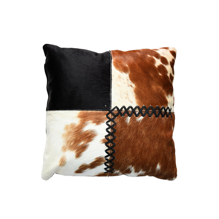 Decorative pillow with black, brown, and white cowhide pattern on a white background