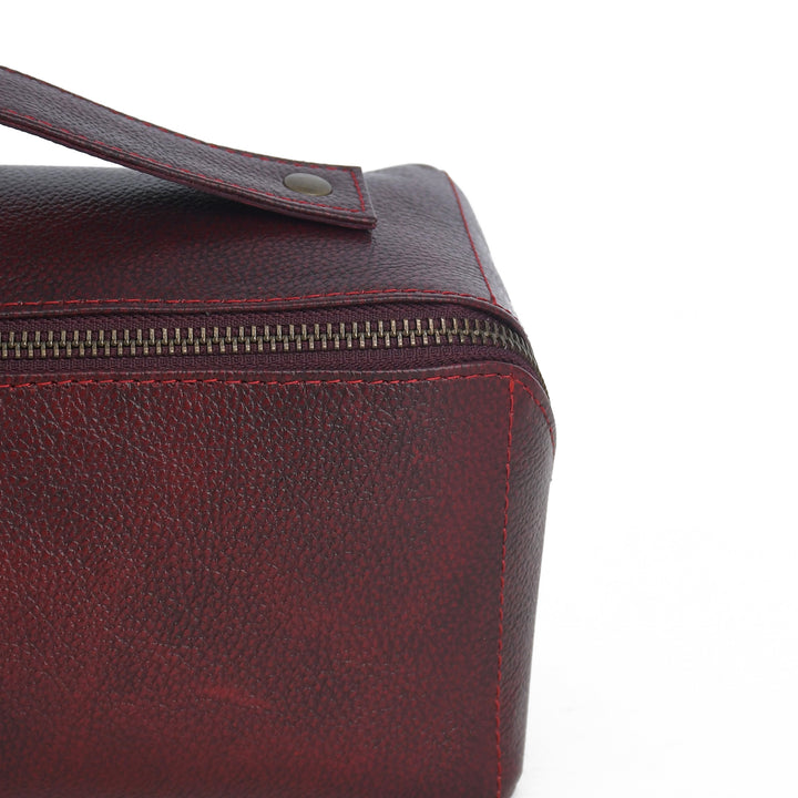 Close-up of a leather toiletry bag with a zipper on a white background
