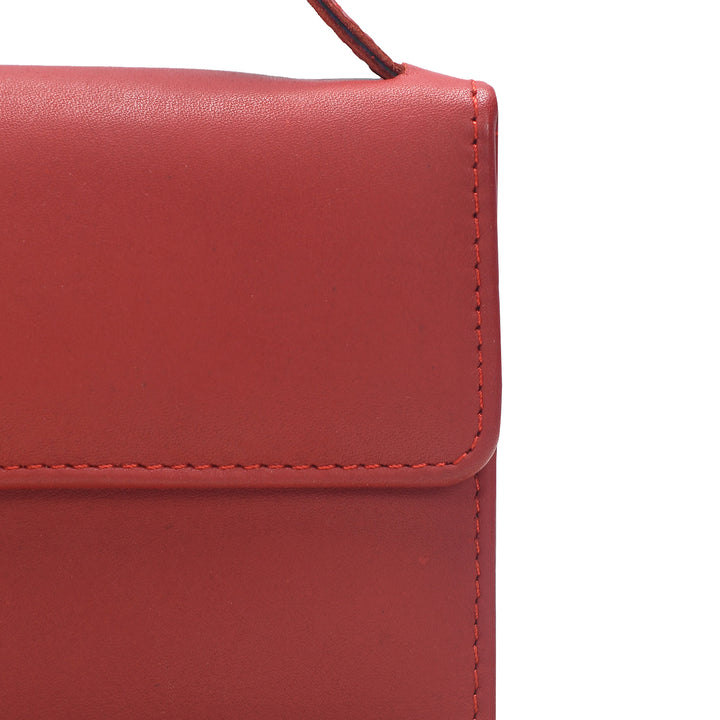 Close-up of a red leather handbag with a white background