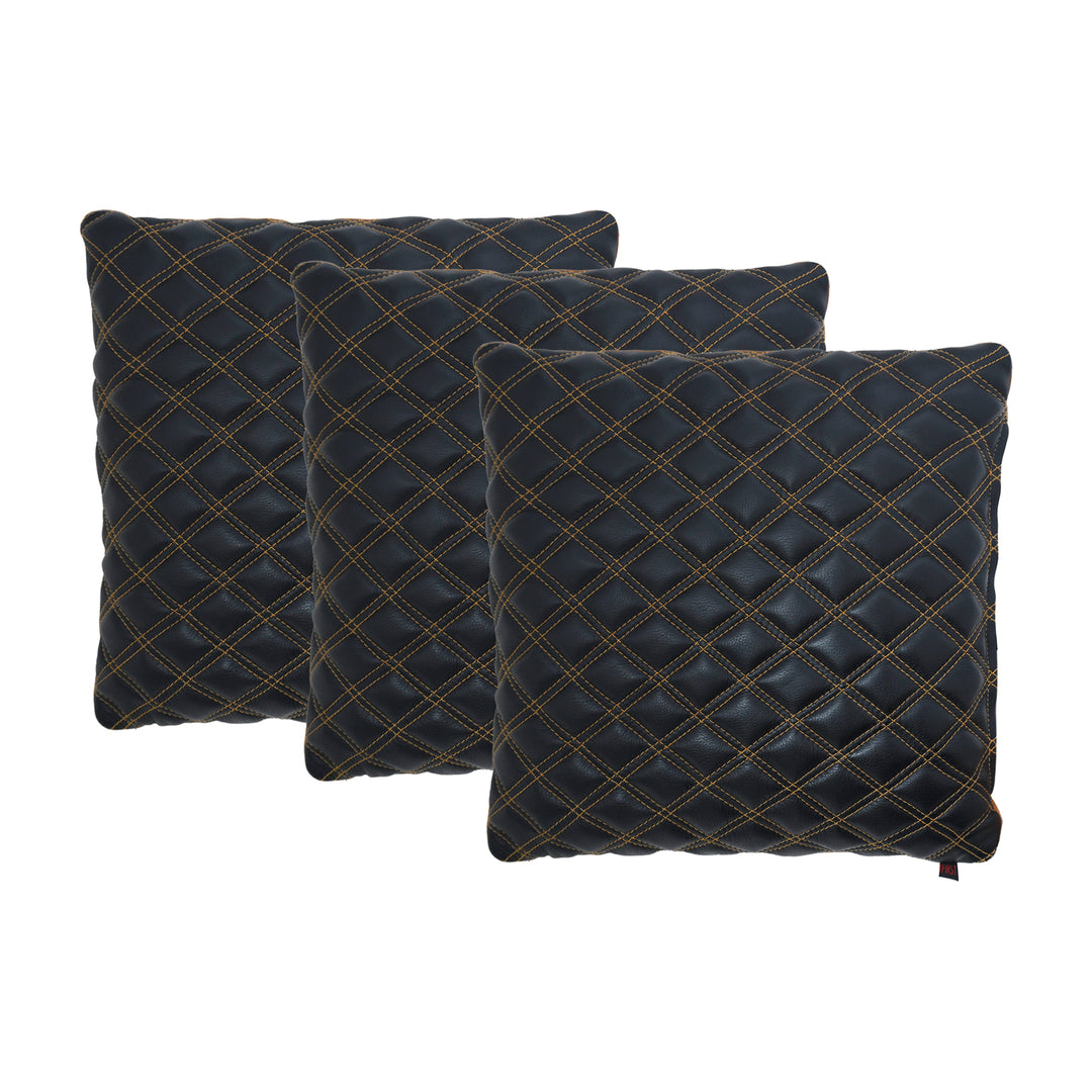 Three dark blue quilted pillows with gold stitching on a white background