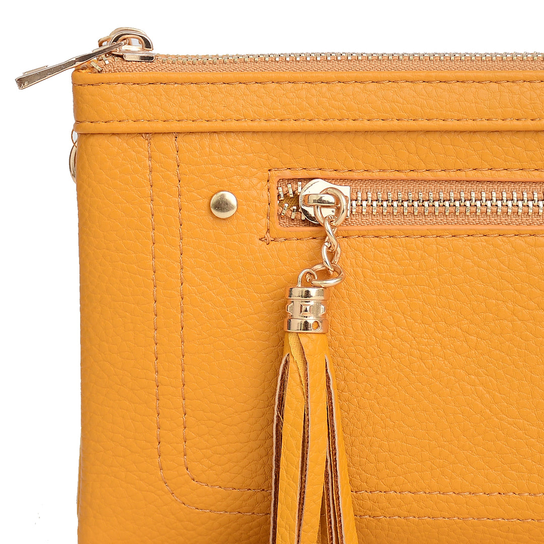 Close-up of a mustard yellow handbag with a zipper and tassel on a white background