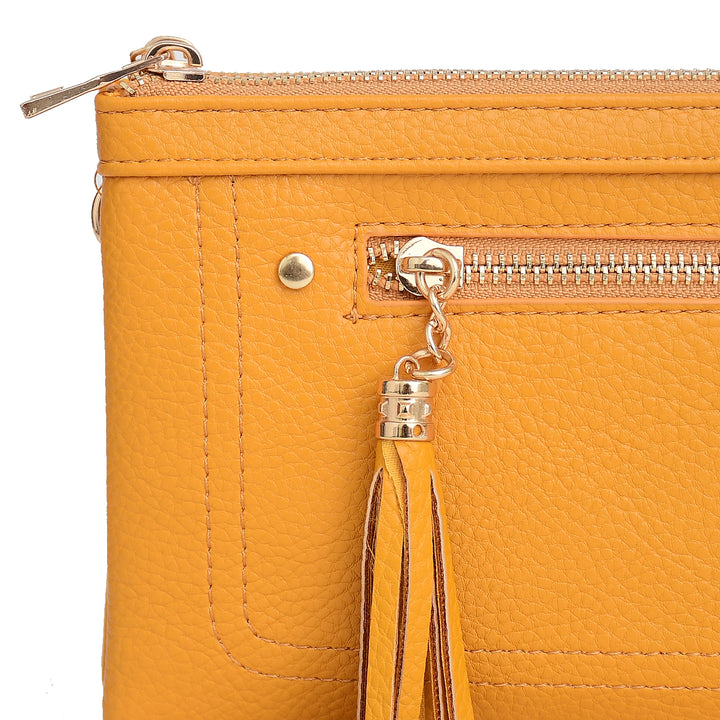 Close-up of a mustard yellow handbag with a zipper and tassel on a white background