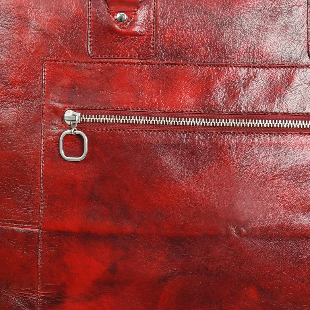 Close-up of a red leather bag with a zipper