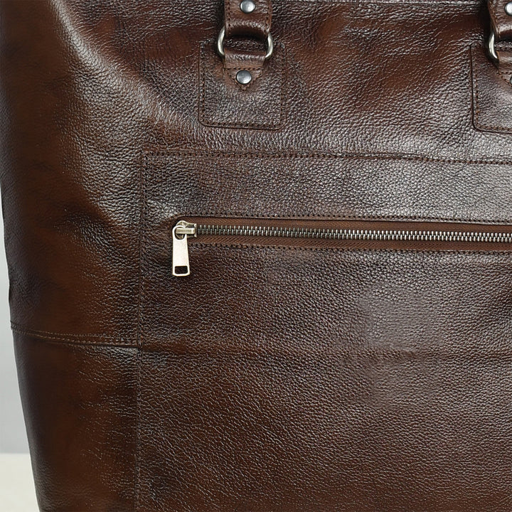 Close-up of a brown leather bag with a zipper