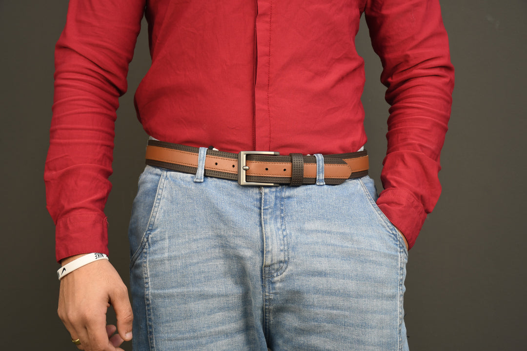 Person wearing a red shirt and blue jeans with a brown belt on a gray background