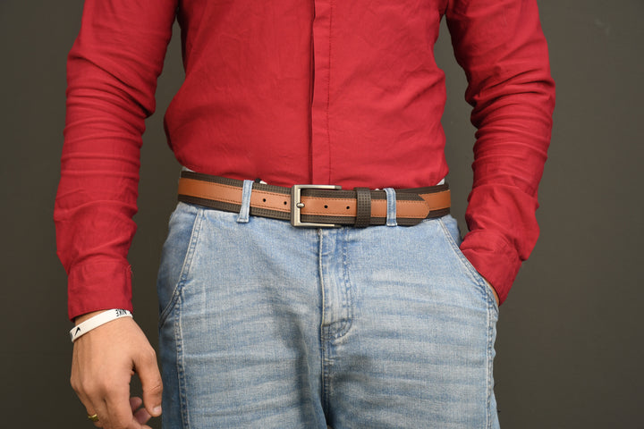 Person wearing a red shirt and blue jeans with a brown belt on a gray background