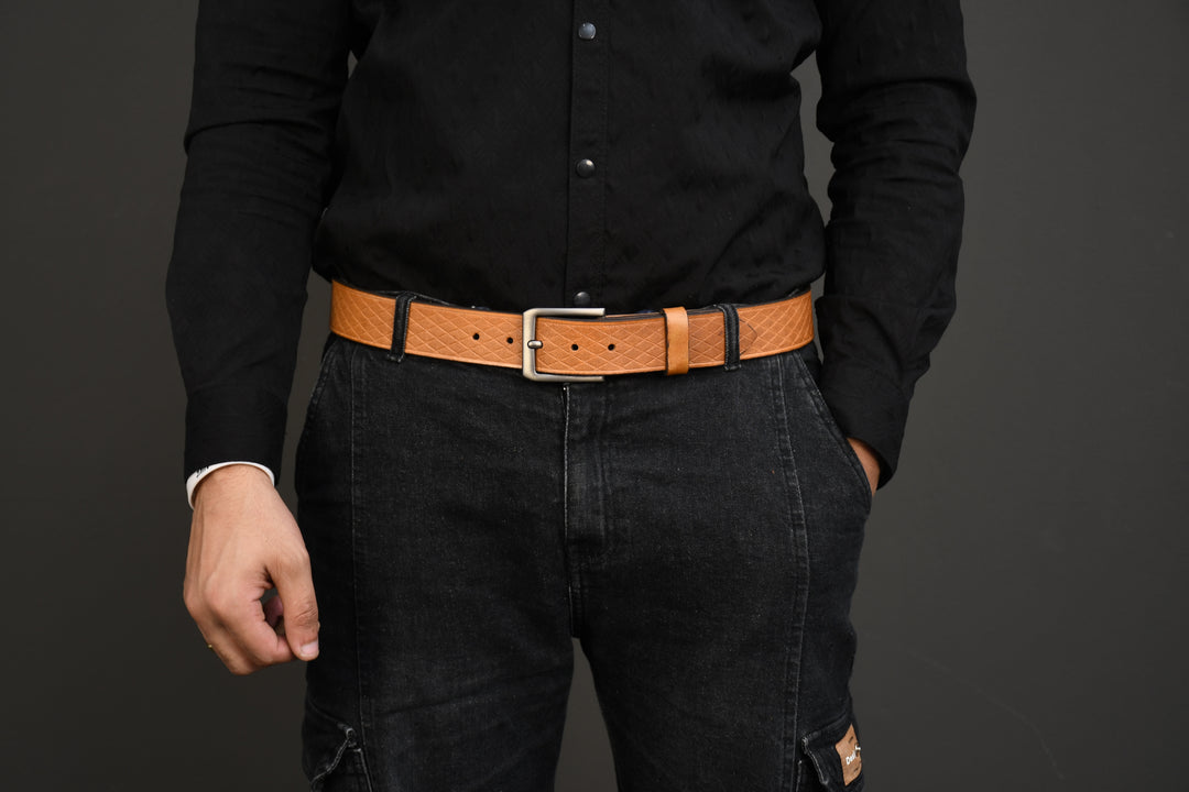 Person wearing a black shirt and dark jeans with a brown belt on a gray background