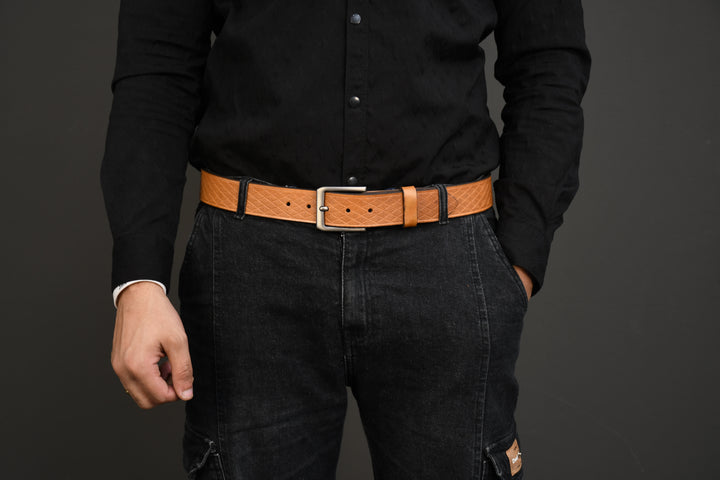 Person wearing a black shirt and dark jeans with a brown belt on a gray background
