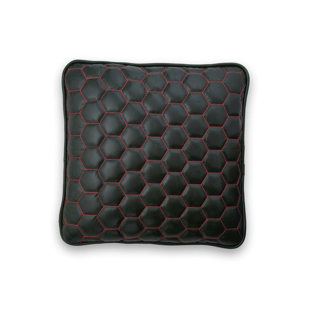 Black hexagonal patterned cushion with red stitching on a white background