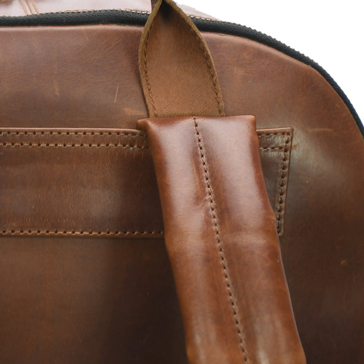 Close-up of a brown leather bag with a strap