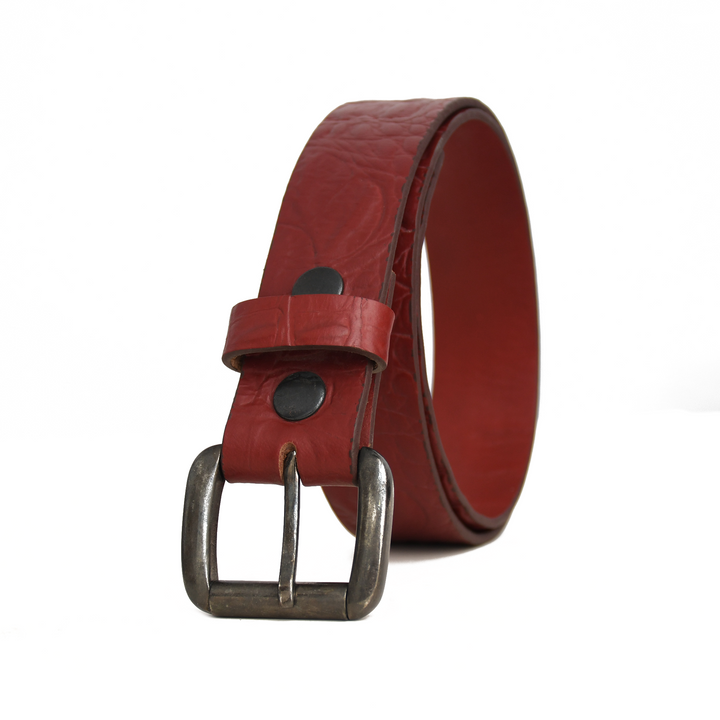 Red leather belt with a silver buckle on a white background