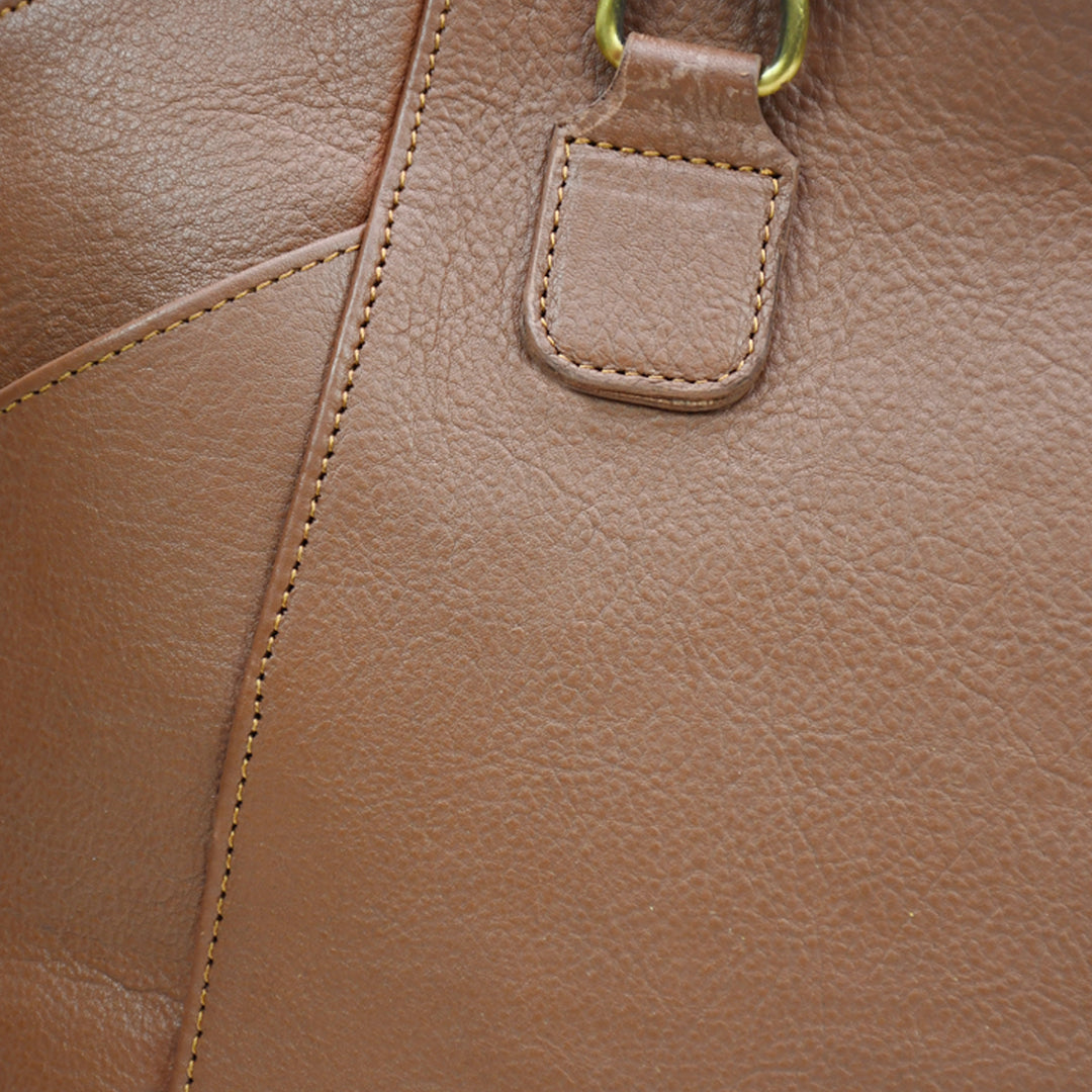 Close-up of a brown leather handbag with visible stitching