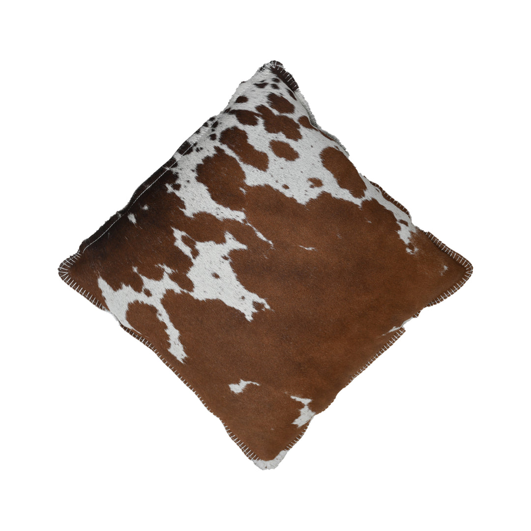 Brown and white cowhide patterned pillow on a white background