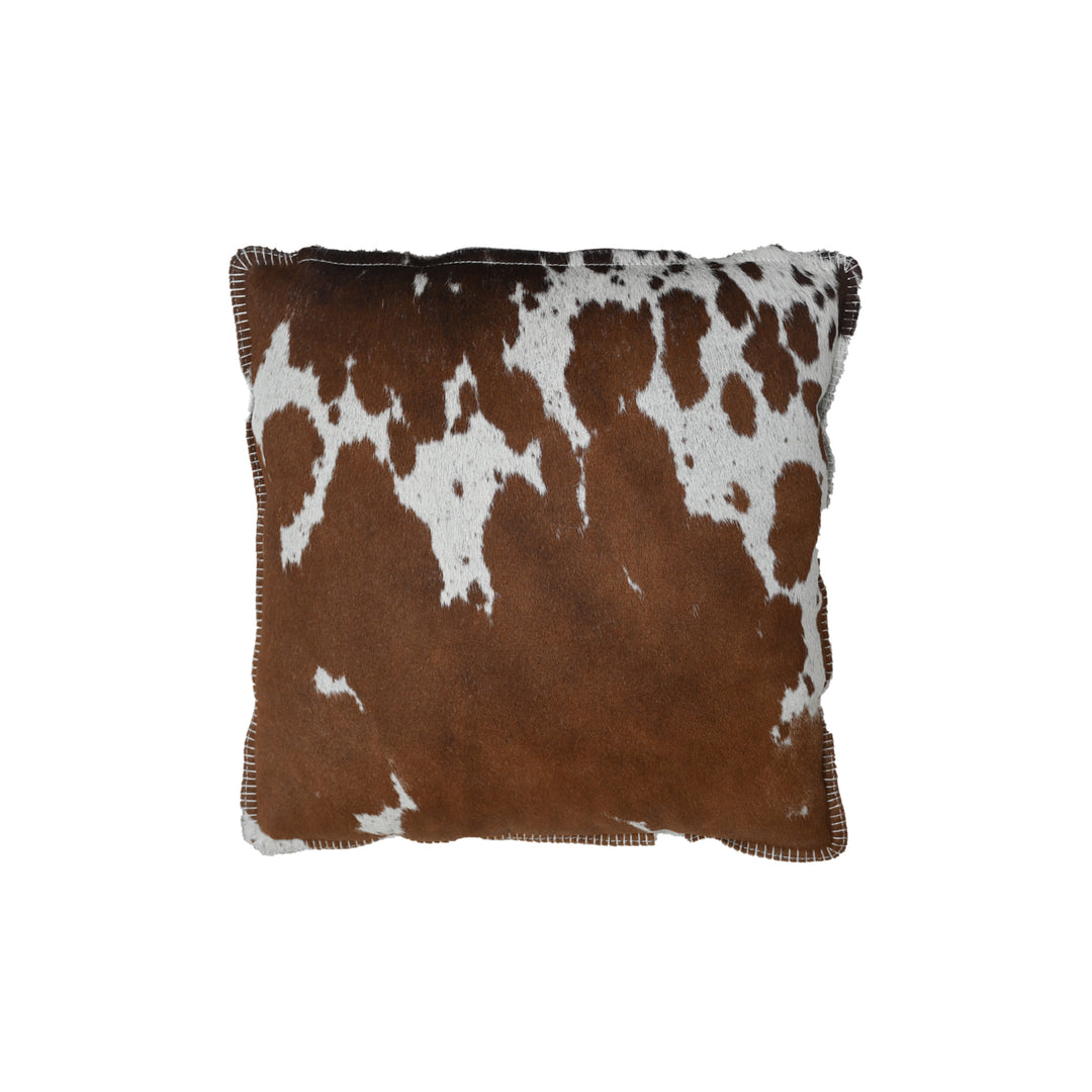 Brown and white cowhide patterned pillow on a white background