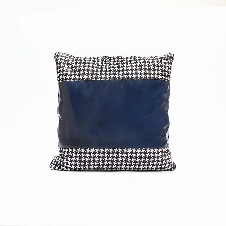 Decorative pillow with houndstooth pattern and navy blue center on a white background