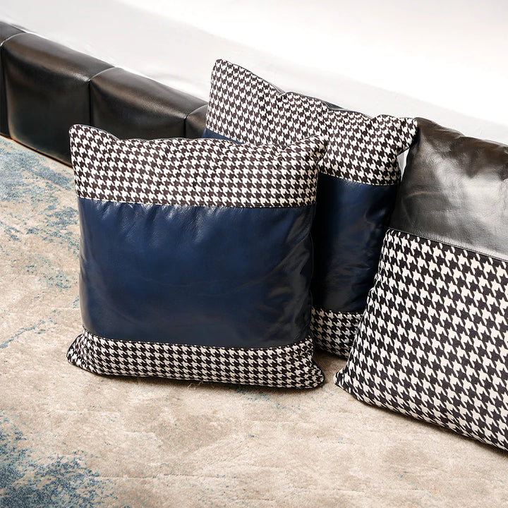 Houndstooth patterned pillows on a sofa with a textured rug underneath.