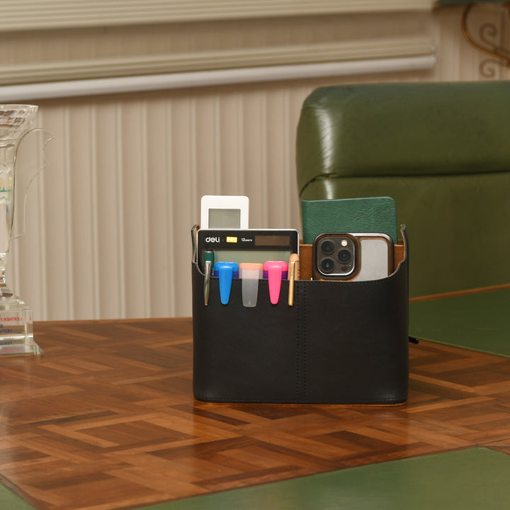 Black leather pouch with various items on a wooden table