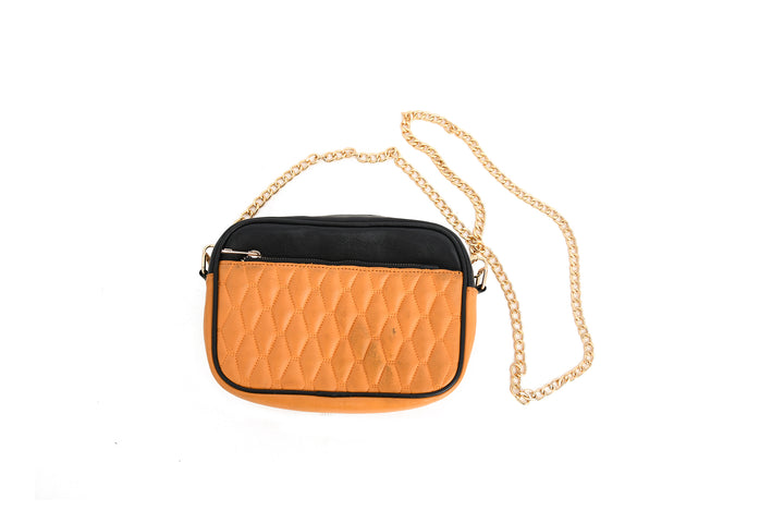 Orange quilted handbag with a gold chain on a white background