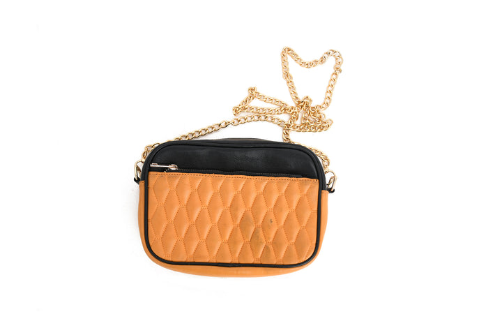 Orange quilted handbag with a gold chain on a white background