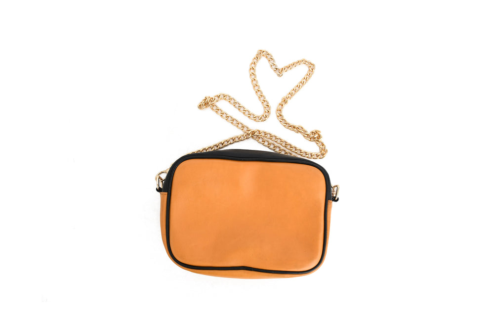 Orange handbag with a gold chain on a white background