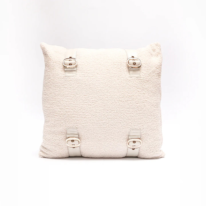 Textured beige pillow with button details on a white background
