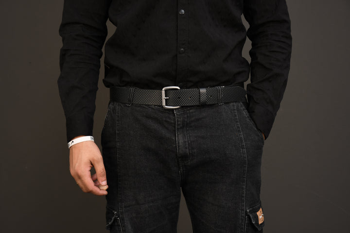 Person wearing a black shirt and dark pants against a gray background