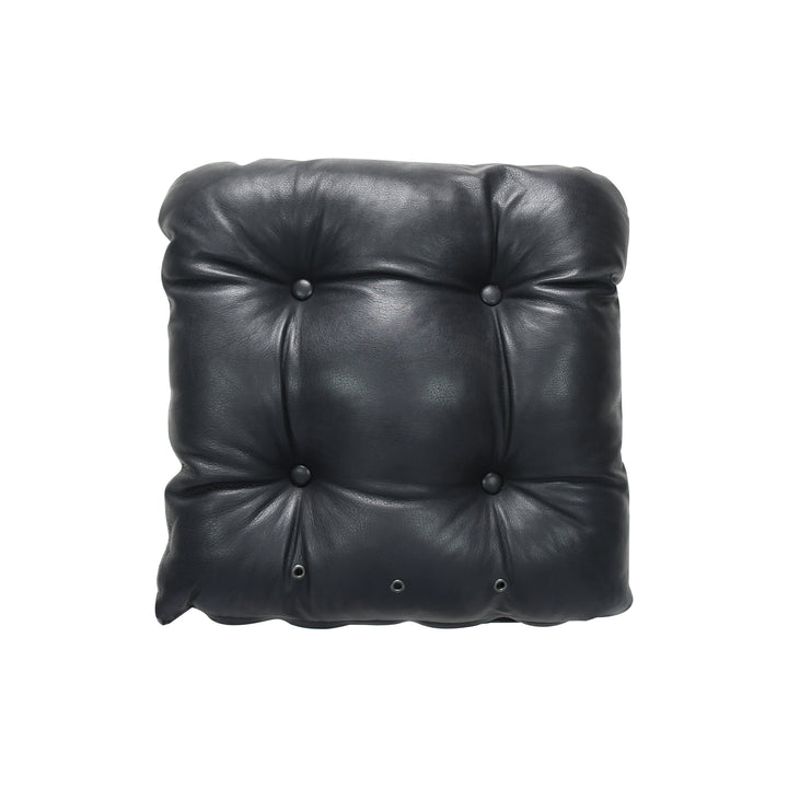 Black leather cushion with button tufting on a white background