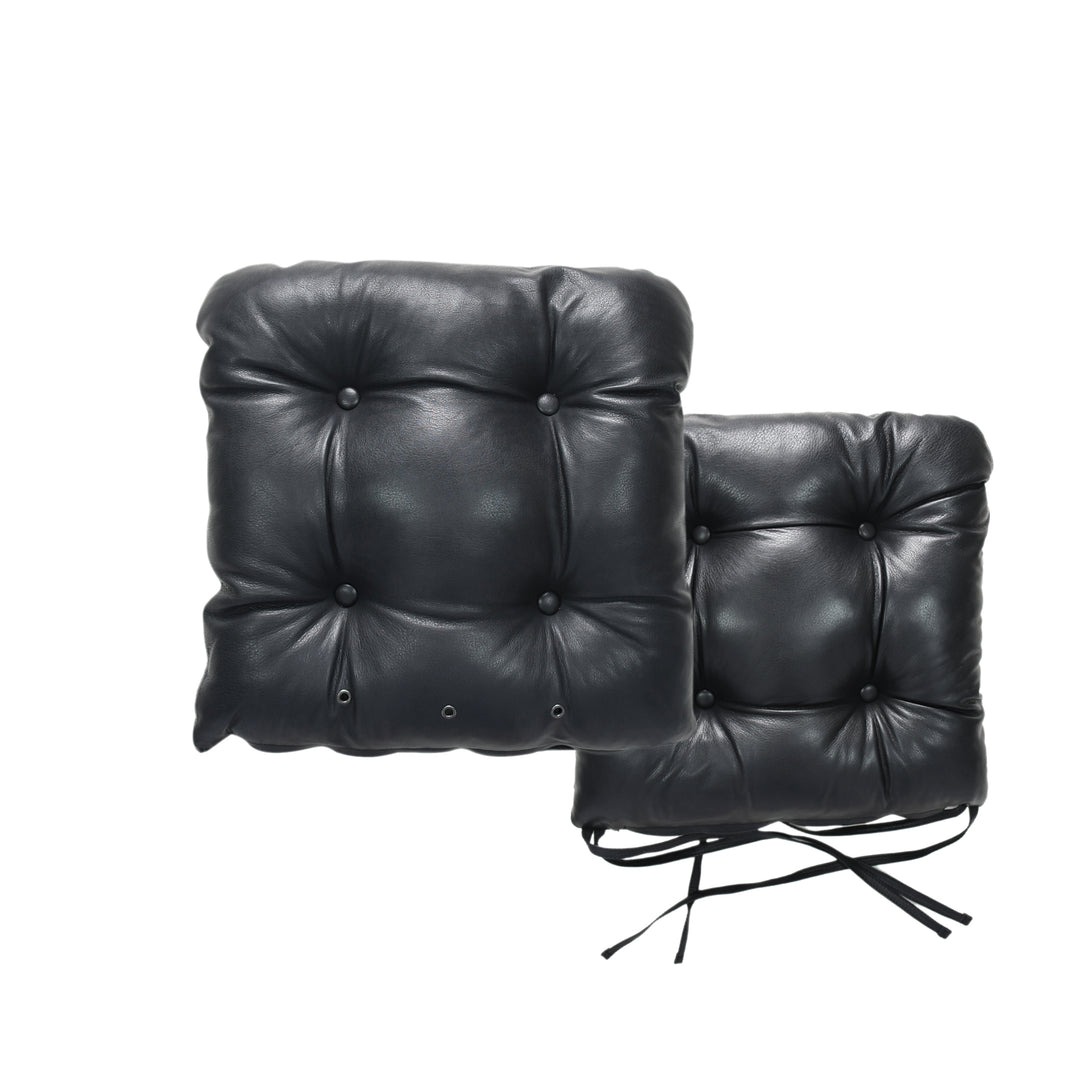 Two black leather chair cushions on a white background