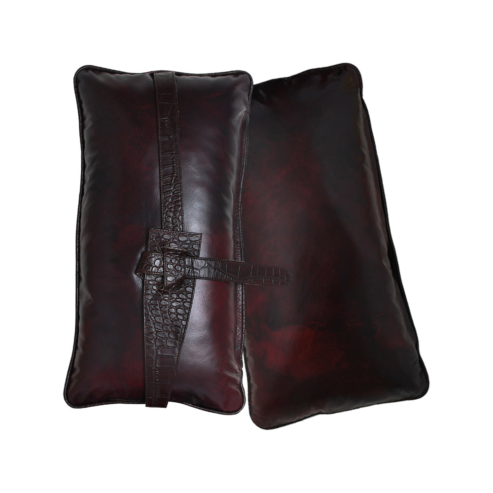 Pair of dark brown leather pillows on a white background