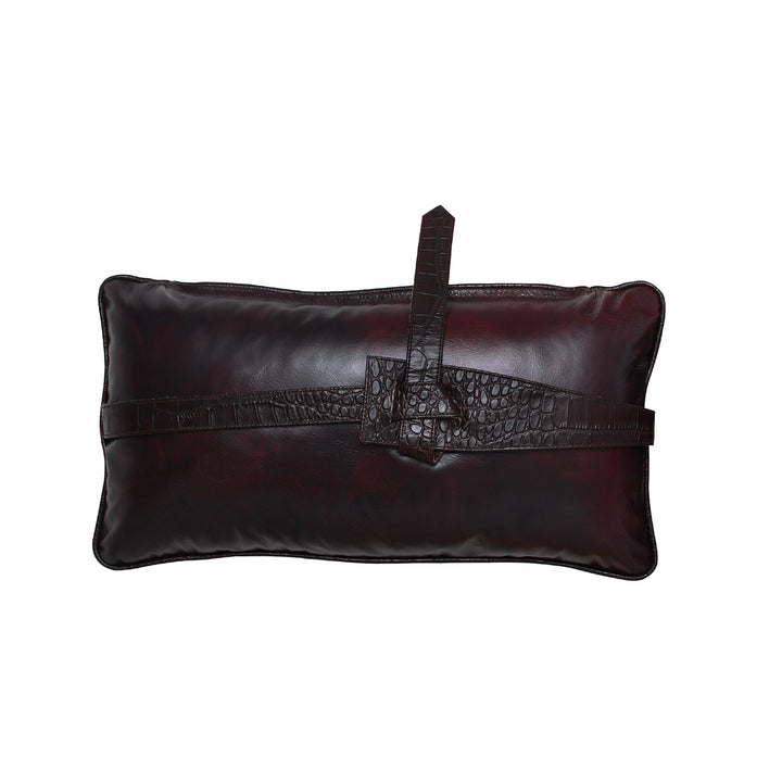 Dark brown leather cushion with a crocodile pattern strap on a white background