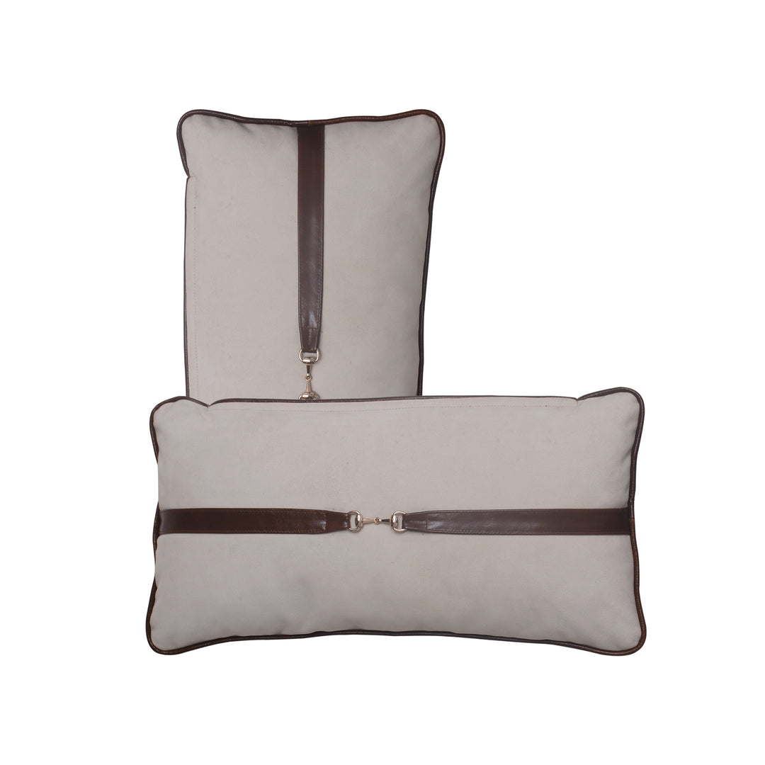 Two gray pillows with brown leather straps on a white background