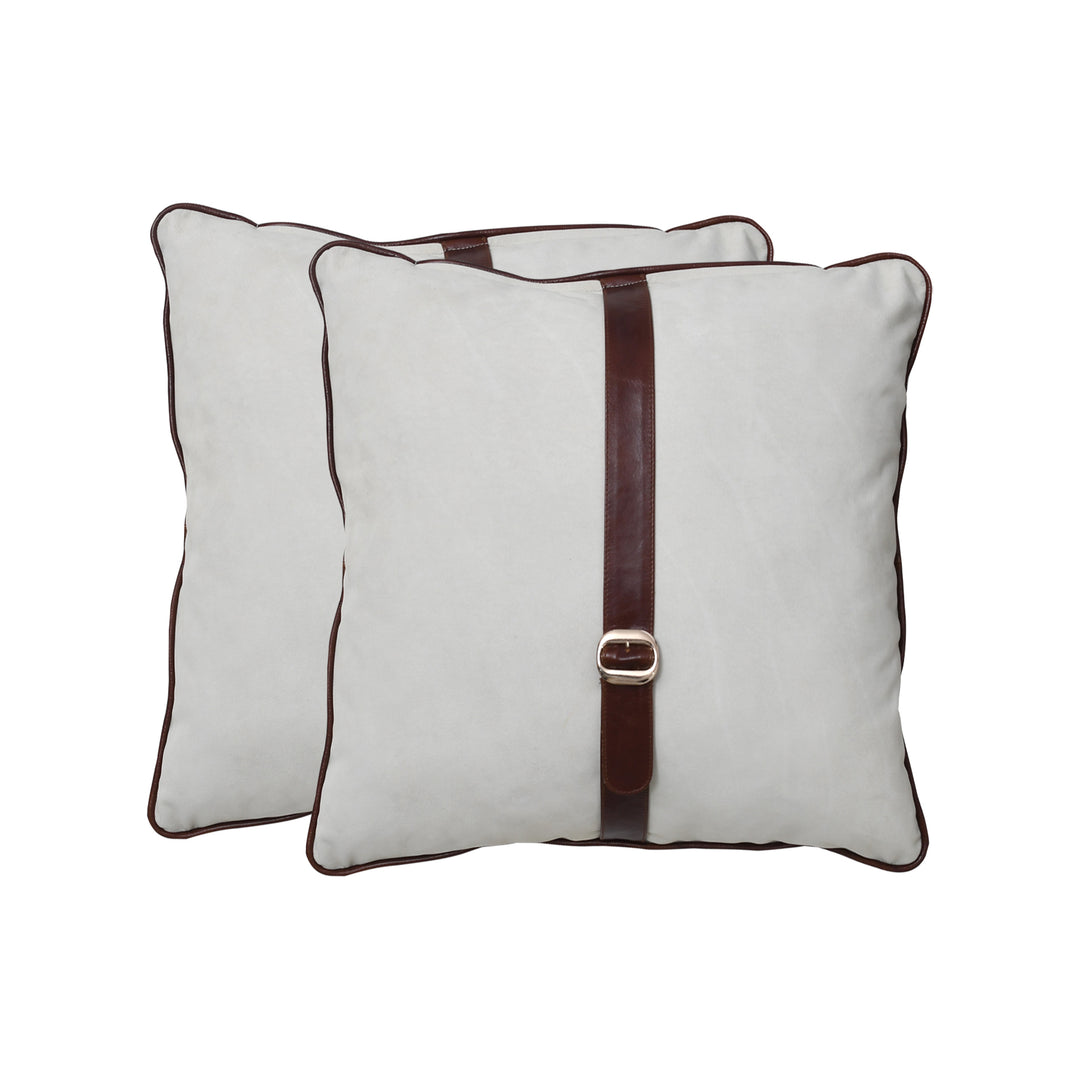 Two beige pillows with brown straps and buckles on a white background