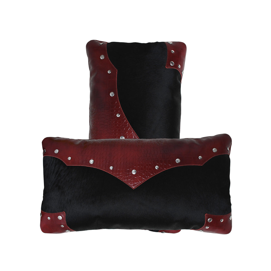 Two black and red leather pillows with silver studs on a white background