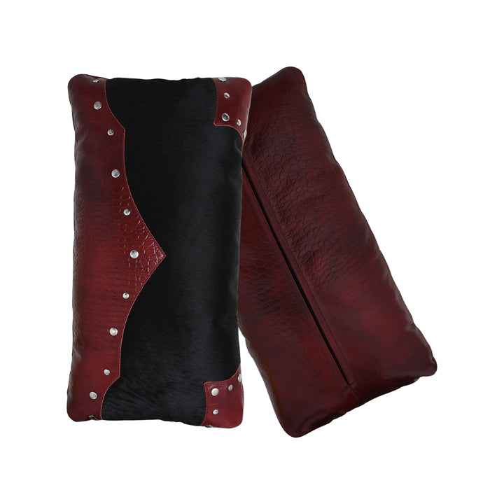 Black and red leather pillow with silver studs on a white background