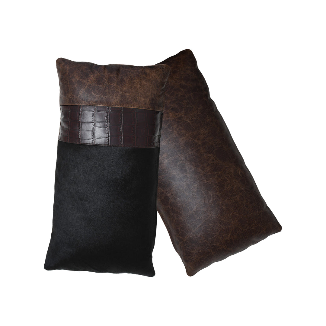 Two leather pillows, one brown and one black, on a white background