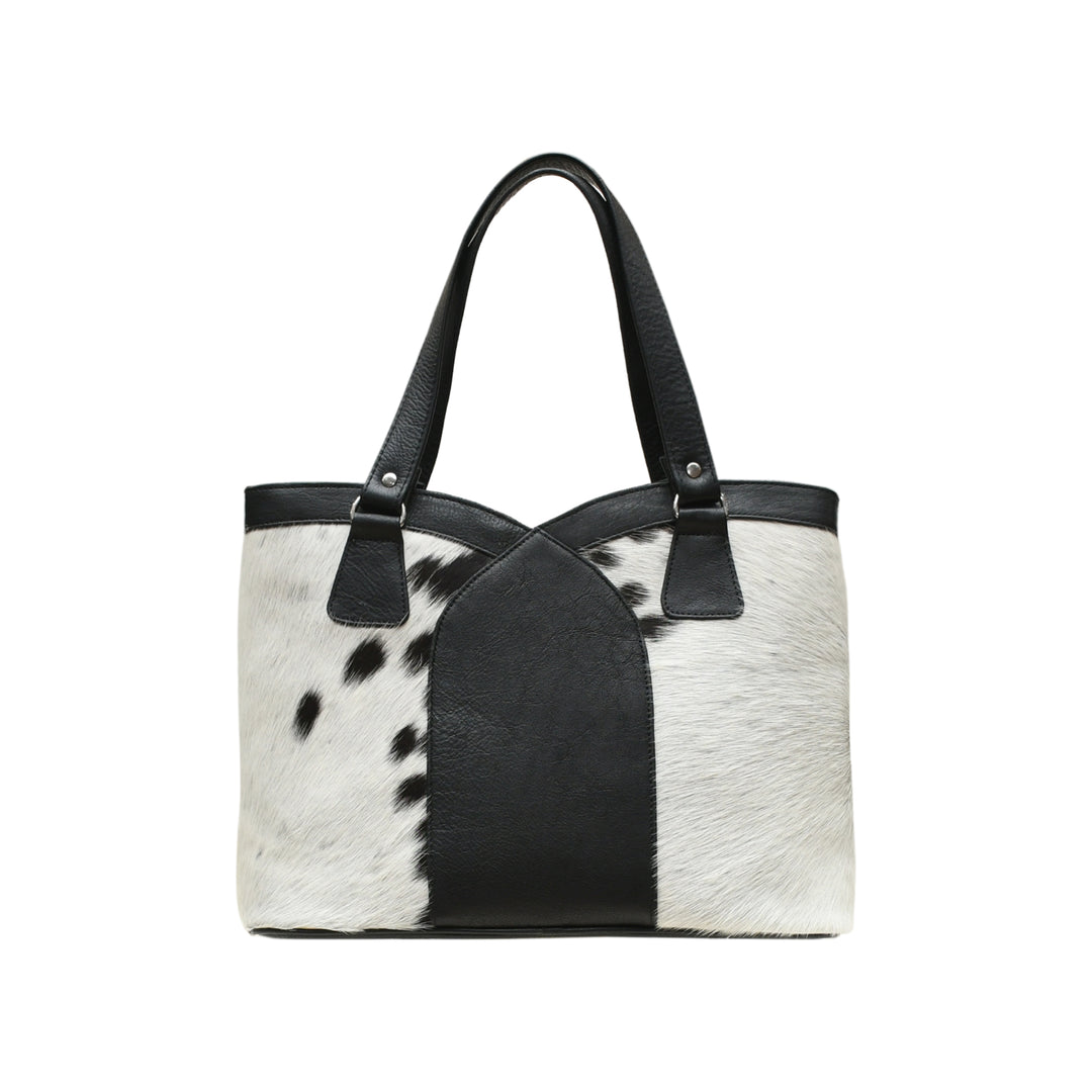 Black and white cowhide handbag on a white background