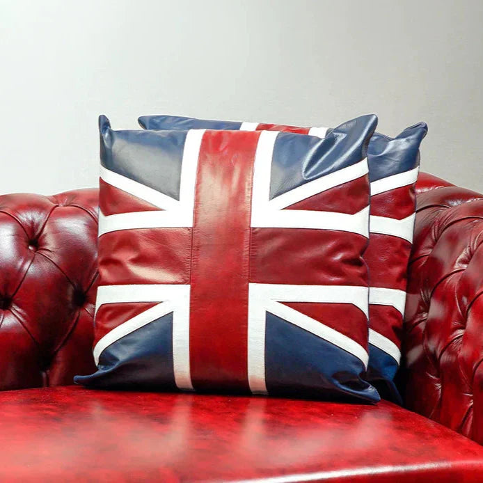 Union Jack pillow on a red leather sofa against a light gray background