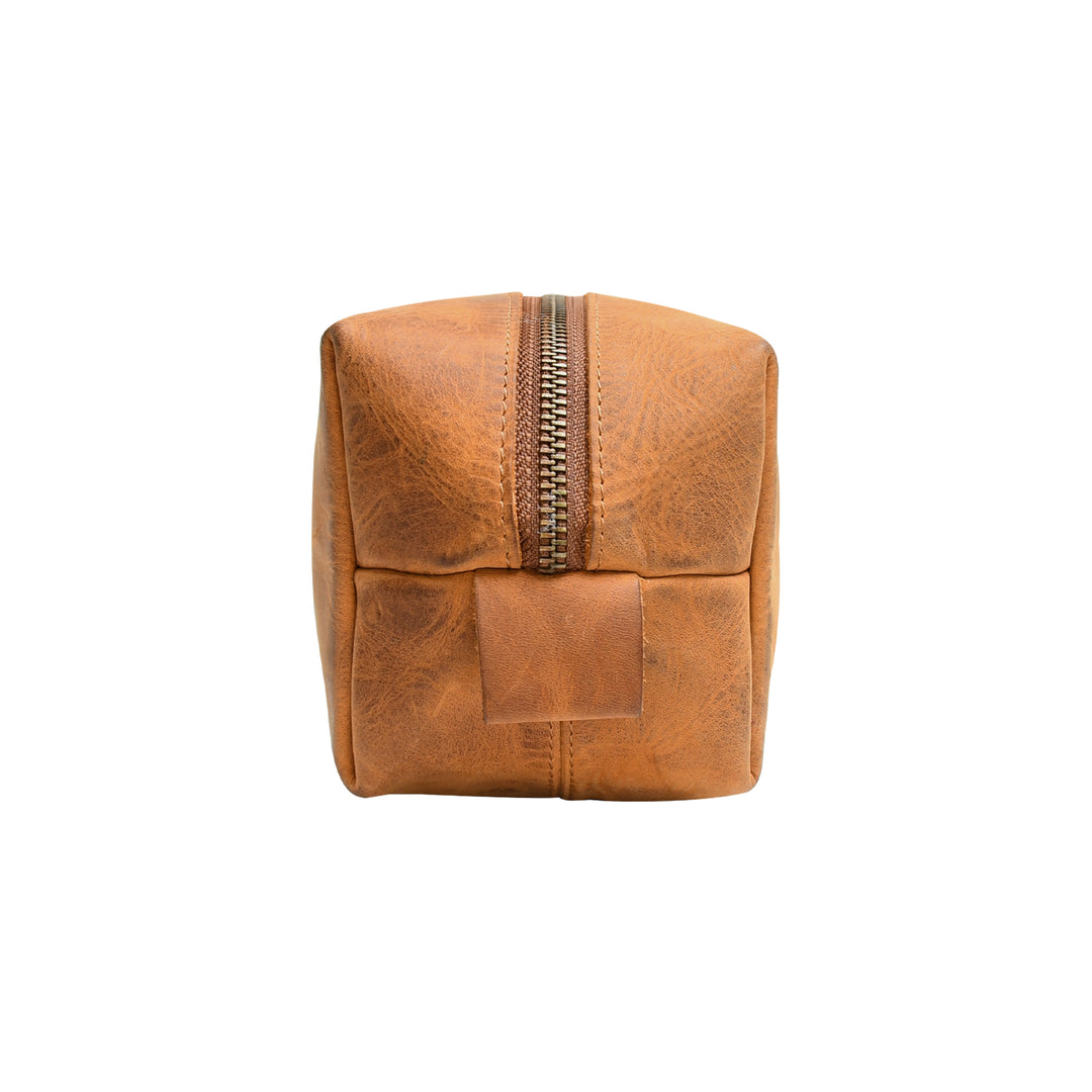 Brown leather toiletry bag with a gold zipper on a white background